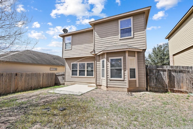 rear view of house featuring a lawn, a fenced backyard, and a patio area