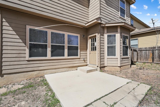 property entrance featuring a patio and fence