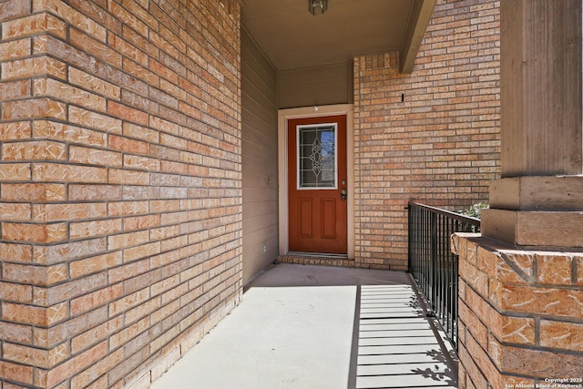 view of exterior entry featuring brick siding