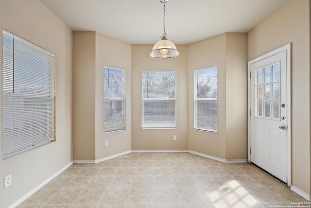 unfurnished dining area featuring light tile patterned flooring and baseboards