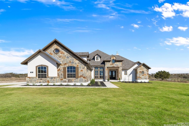 french provincial home featuring stone siding and a front lawn