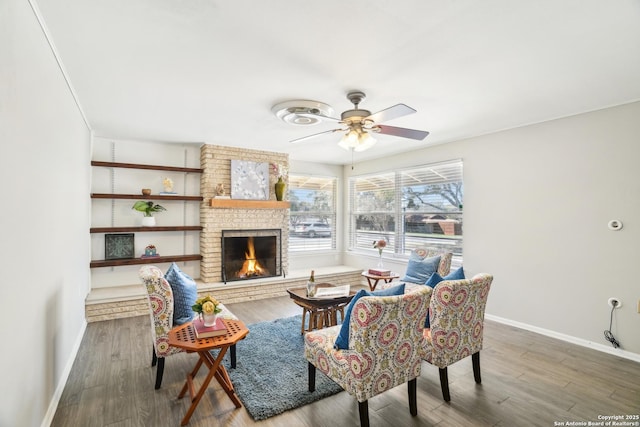 living room with a fireplace, wood finished floors, baseboards, and ceiling fan