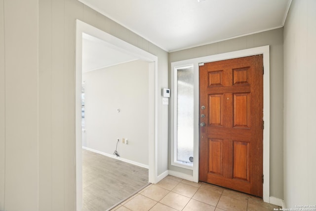 entrance foyer featuring light tile patterned floors, baseboards, and ornamental molding