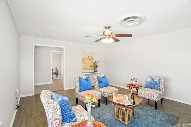 sitting room with ceiling fan, baseboards, and wood finished floors