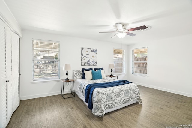 bedroom with wood finished floors, baseboards, a closet, and ceiling fan