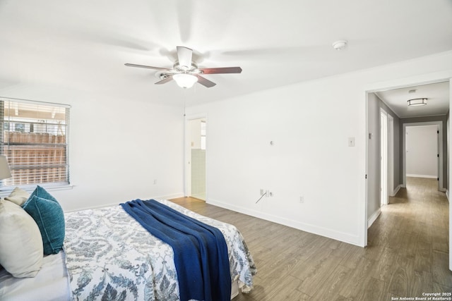 bedroom featuring ceiling fan, baseboards, and wood finished floors