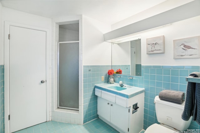 bathroom featuring vanity, tile walls, toilet, and a stall shower