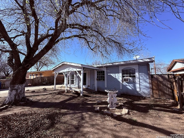 view of front of house featuring fence and brick siding