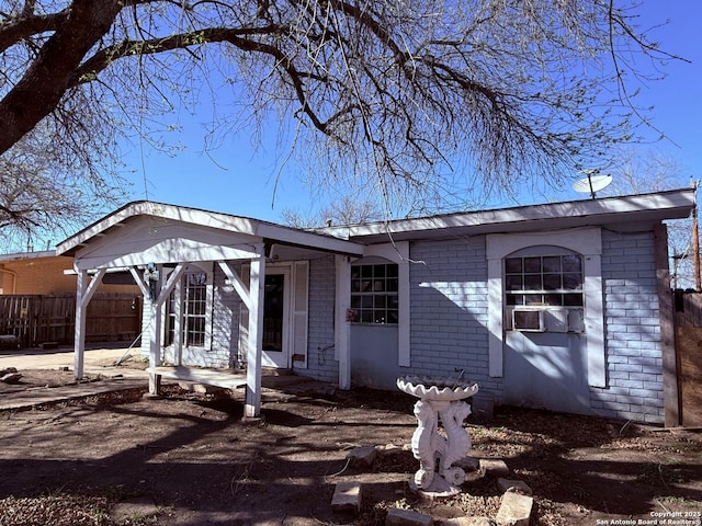 view of front facade featuring brick siding and fence