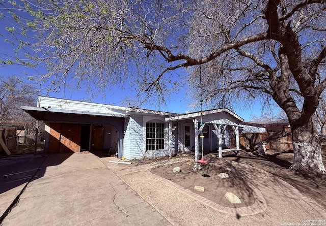 view of front of house featuring driveway and fence