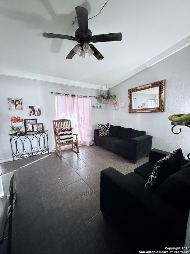 living room with lofted ceiling, dark tile patterned flooring, and a ceiling fan