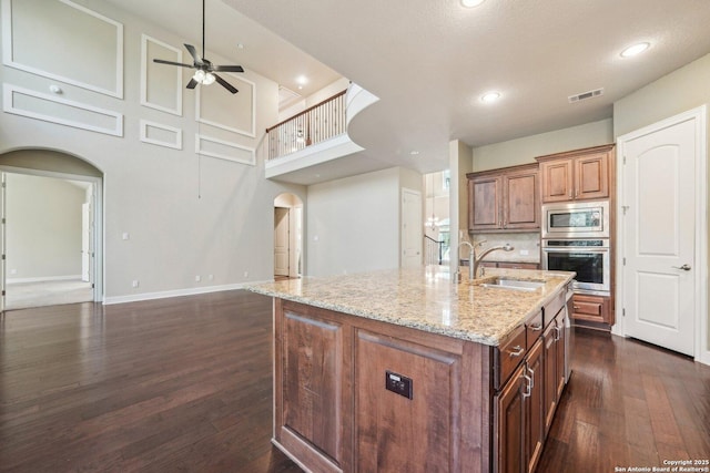 kitchen featuring a ceiling fan, visible vents, arched walkways, a sink, and appliances with stainless steel finishes