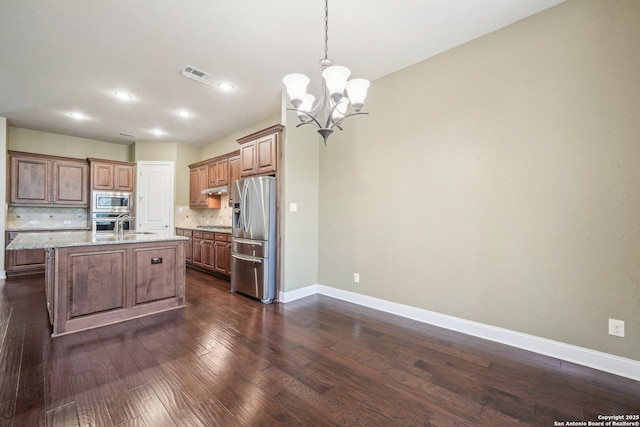 kitchen featuring visible vents, stainless steel appliances, dark wood-type flooring, under cabinet range hood, and backsplash