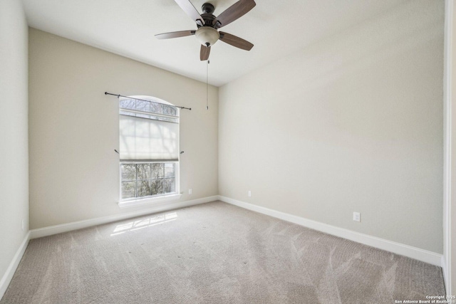 carpeted empty room with ceiling fan and baseboards