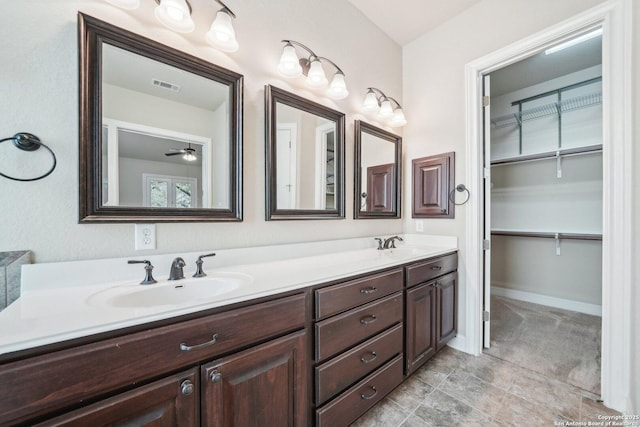 bathroom with double vanity, visible vents, baseboards, and a sink