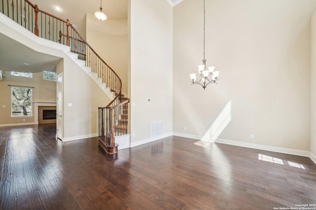 interior space with visible vents, hardwood / wood-style floors, a fireplace, baseboards, and stairs