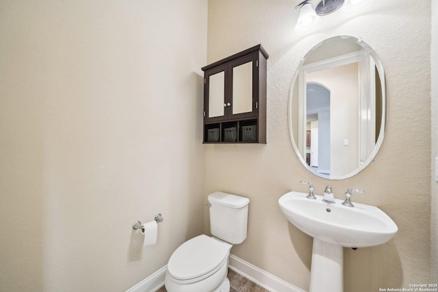 bathroom featuring toilet and baseboards