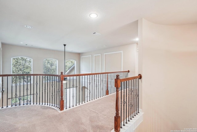 hall featuring visible vents and carpet floors