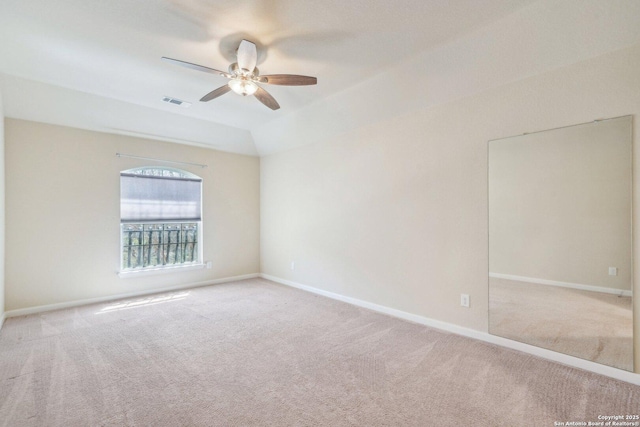 carpeted spare room with visible vents, a ceiling fan, and baseboards