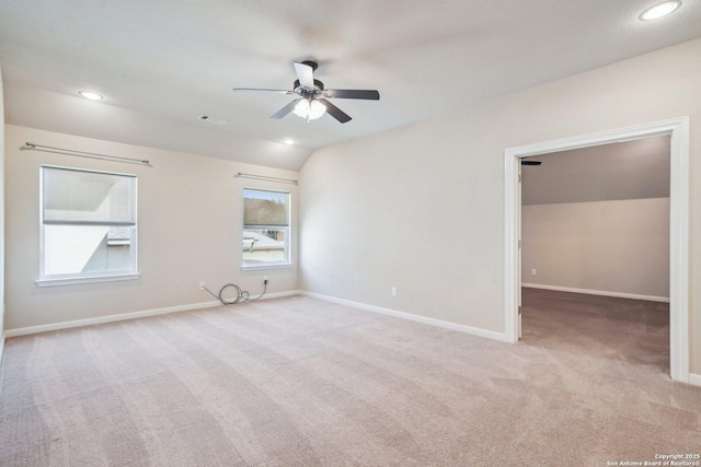 spare room with baseboards, light colored carpet, lofted ceiling, and a ceiling fan