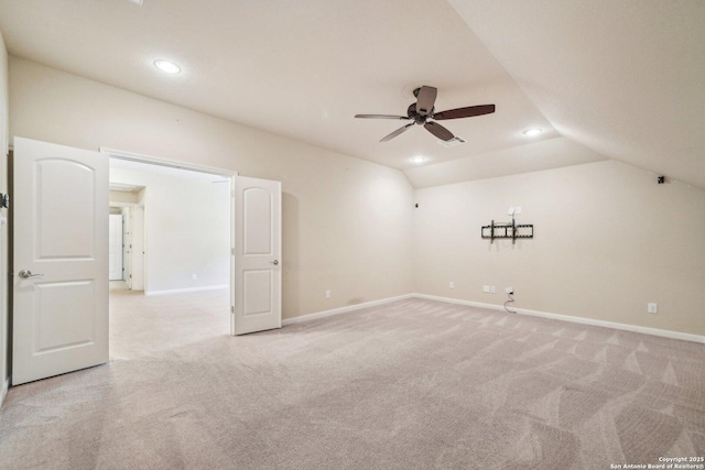 unfurnished room featuring baseboards, vaulted ceiling, light carpet, recessed lighting, and a ceiling fan