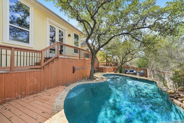 view of swimming pool with stairway, fence, a fenced in pool, and a wooden deck