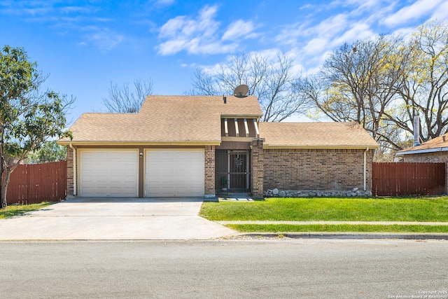 view of front facade with a front lawn, driveway, fence, an attached garage, and brick siding