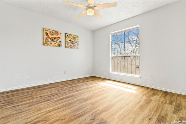 empty room with baseboards, a textured ceiling, a ceiling fan, and wood finished floors