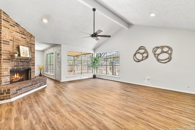 unfurnished living room with a fireplace, lofted ceiling with beams, and wood finished floors