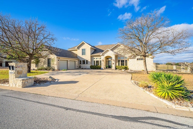 view of front of property featuring stone siding, driveway, and an attached garage