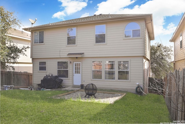 back of house with a lawn and fence