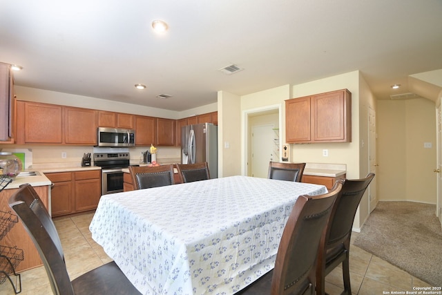 kitchen with light countertops, light tile patterned floors, visible vents, and appliances with stainless steel finishes