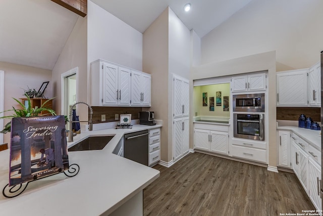 kitchen featuring a sink, light countertops, appliances with stainless steel finishes, white cabinetry, and dark wood-style flooring