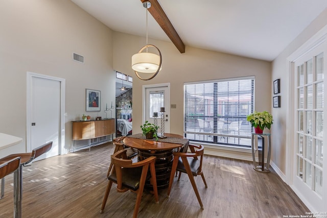 dining area featuring vaulted ceiling with beams, wood finished floors, visible vents, and baseboards