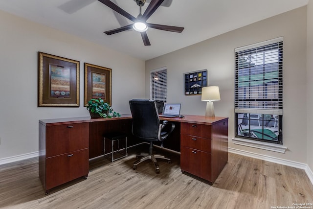 home office featuring baseboards, light wood-style floors, and ceiling fan