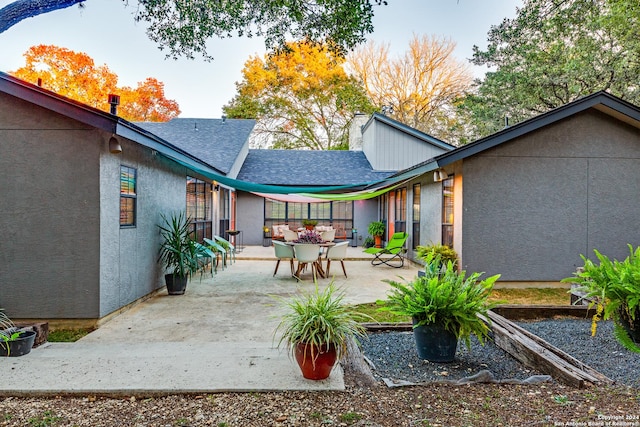 back of house with stucco siding, a patio, and a shingled roof