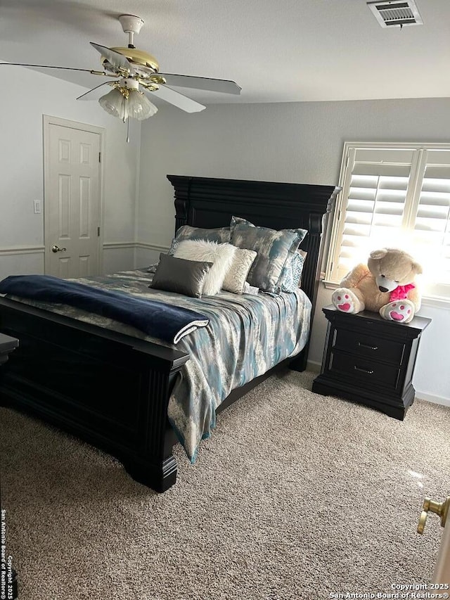 bedroom with carpet flooring, visible vents, and ceiling fan