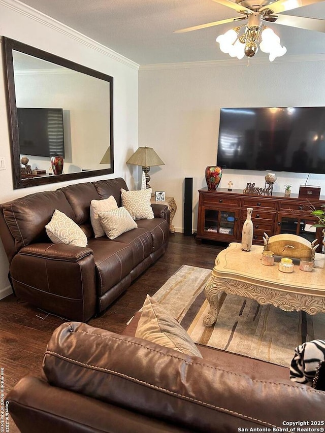 living room with ceiling fan, wood finished floors, baseboards, and ornamental molding