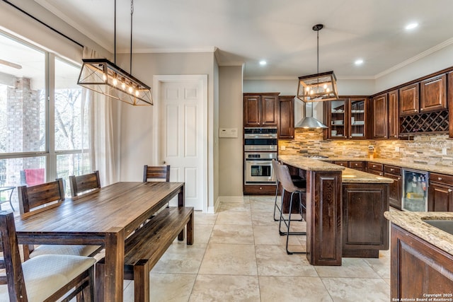 kitchen featuring tasteful backsplash, dark brown cabinets, wine cooler, double oven, and wall chimney exhaust hood