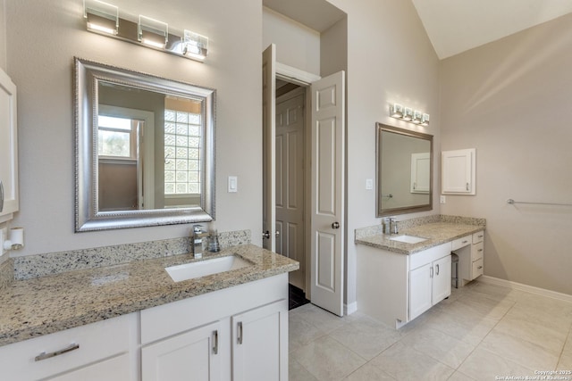 bathroom with tile patterned floors, two vanities, and a sink