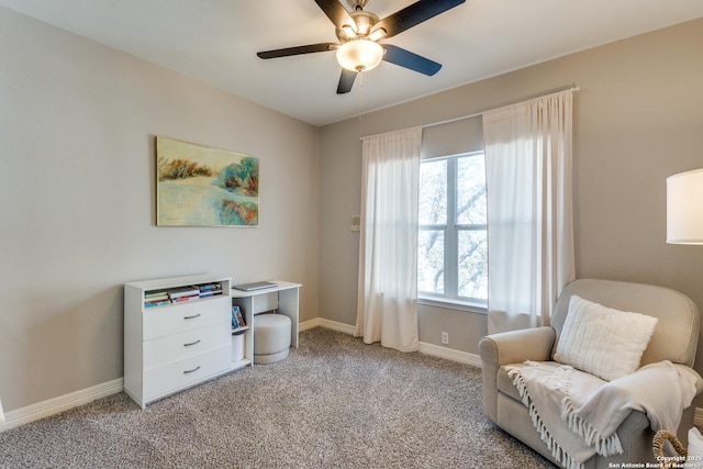 living area with light carpet, a ceiling fan, and baseboards