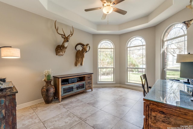 office with a raised ceiling, plenty of natural light, a ceiling fan, and baseboards