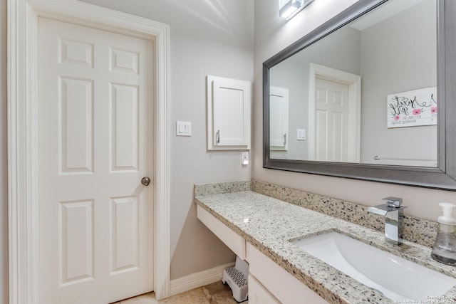 bathroom with baseboards, vanity, and tile patterned flooring