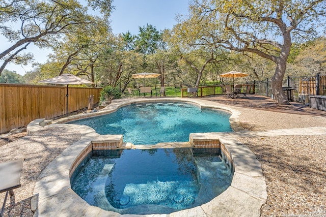 view of swimming pool with a patio area, a pool with connected hot tub, outdoor dining area, and a fenced backyard