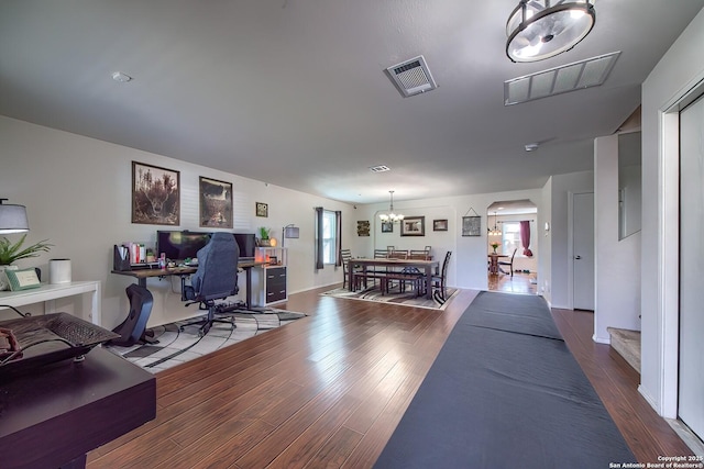 interior space featuring wood finished floors, visible vents, a chandelier, and arched walkways