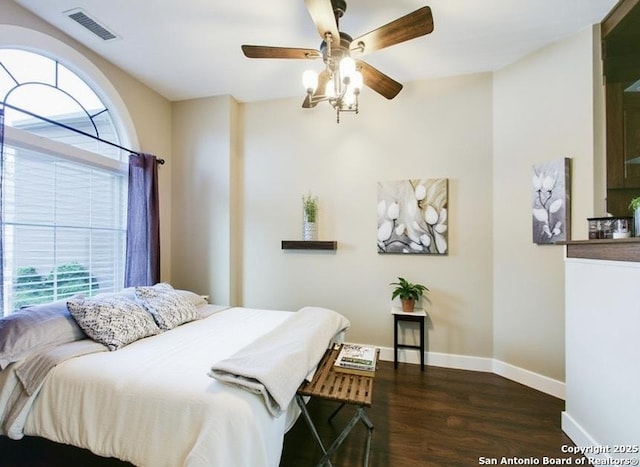 bedroom with dark wood finished floors, baseboards, visible vents, and a ceiling fan