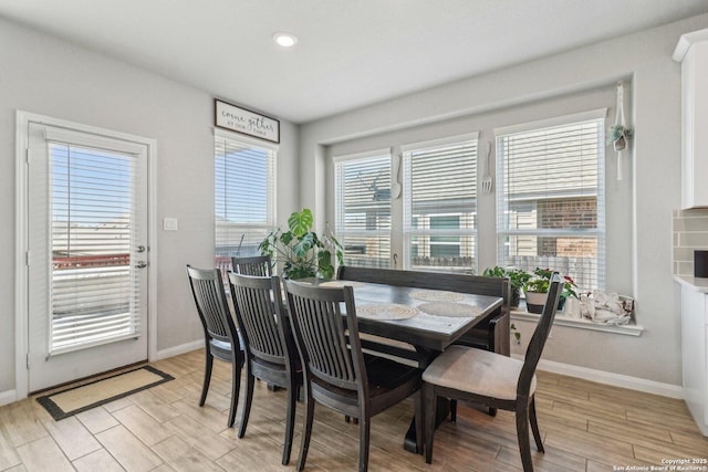 dining area with baseboards and light wood finished floors