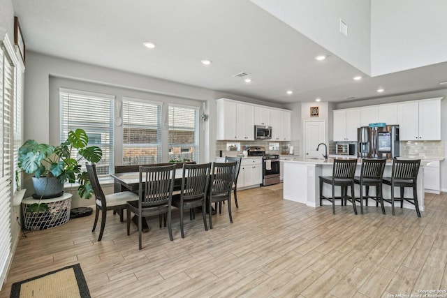 dining space featuring recessed lighting, visible vents, and light wood finished floors