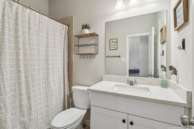 bathroom featuring curtained shower, toilet, vanity, and a textured wall