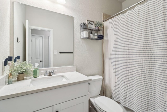 bathroom featuring a shower with shower curtain, toilet, vanity, and a textured wall